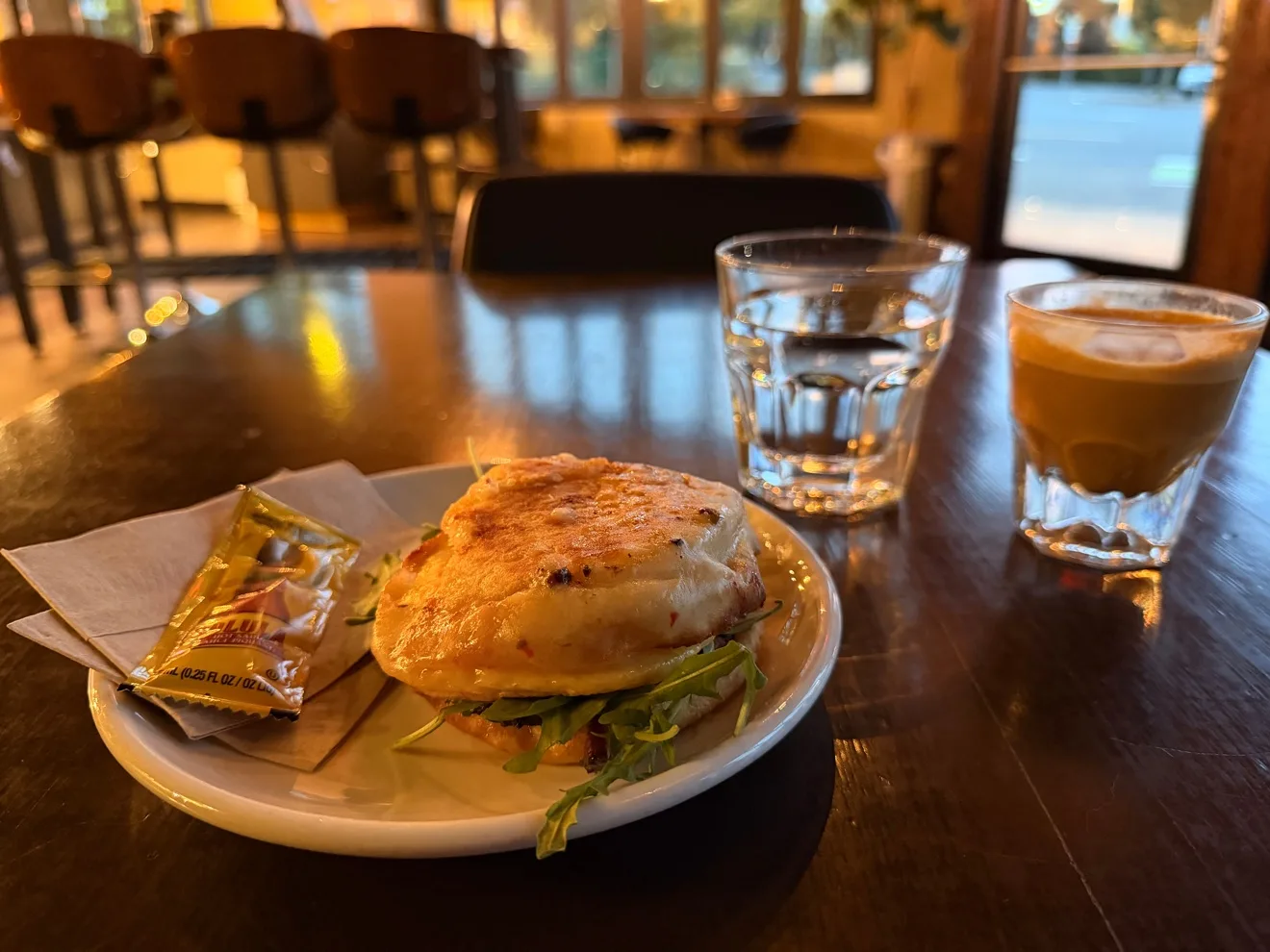 The bacon breakfast sandwich, with the Cortado behind it